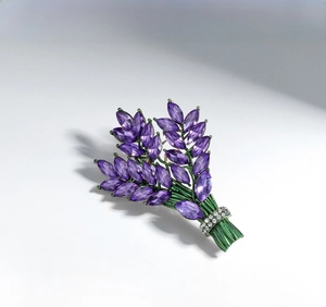Macro shot of lavender brooch with purple marquise stones and green enamel leaves