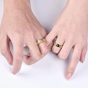Detailed view of gold stainless steel rings with engraved celestial moon and sun patterns