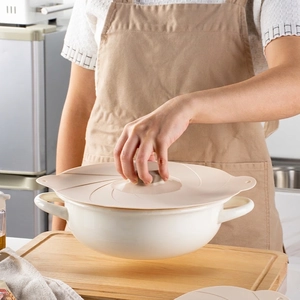Silicone suction lid set shown lifting a ceramic pot to demonstrate vacuum seal strength