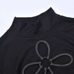 Detail eines schwarzen gerippten Crop-Tops mit halbhohem Kragen und Metallring-Ausschnitt