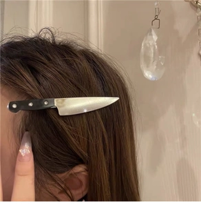 Close-up of a creative silver cleaver hair clip with a black handle worn on hair