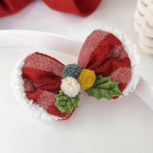 Détail d'une pince à cheveux de Noël festive avec paillettes et pompons doux colorés