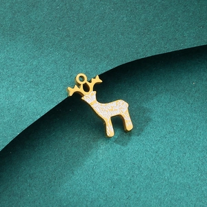 Detailed macro shot of golden reindeer pendant with white enamel on green paper