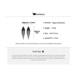 Détail de boucles d'oreilles à pompons géométriques avec dimensions de 9 cm par 2,5 cm