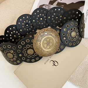 Detailed macro view of bohemian vintage leather waist belt with sun-patterned bronze buckle