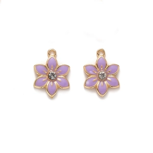 Detailed macro view of purple enamel flower pendants with sparkling white crystals