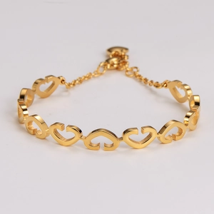 Detailed close-up of golden linked heart-shaped bracelet with lobster clasp and chain