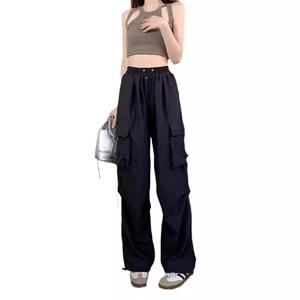 Women's baggy cargo pants in black paired with olive green halter top for street fashion