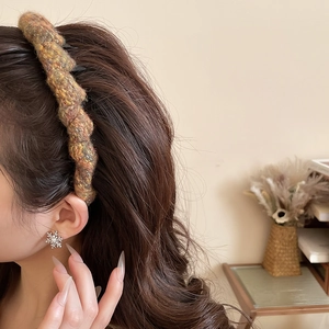 Detail of chunky knit brown wave headband on model showing soft woolen texture