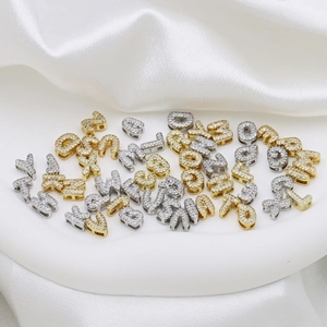 Gold and silver bubble letter necklaces with sparkling zircon pendants on white silk