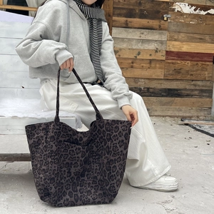 Detailed view of large leopard print tote bag with front pocket and dual shoulder straps