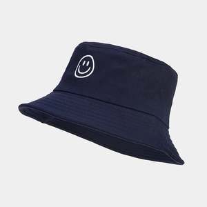 Gros plan du bob bleu marine avec broderie smiley blanche et texture en coton sergé durable