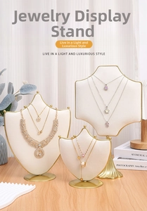 Three jewelry display stands in gold metal and cream velvet for necklaces and bracelets