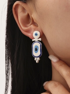 Detailed view of enamel blue evil eye earring pendant with silver metal beads on ear