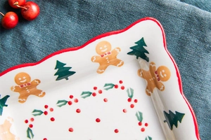 Detail view of festive ceramic plate with gingerbread man and red wavy edge