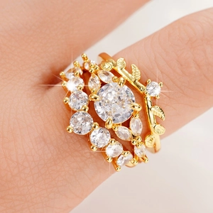Detail shot of golden vintage rings set featuring leaf texture and sparkling crystals