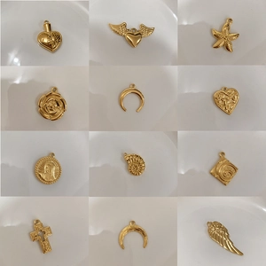 Golden titanium steel charms featuring hearts, crosses, and wings on white background