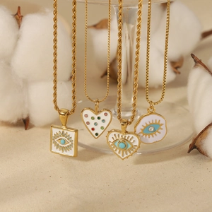 Detalle de collares ojo turco bañados en oro 18k con colgantes de corazón de cristal