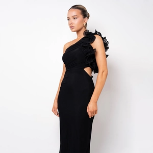 Détail de la robe longue noire à une épaule avec volants et découpe à la taille