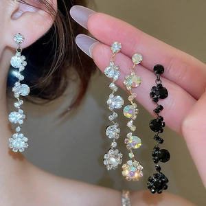 Detail of elegant rhinestone tassel earrings in silver, iridescent, and black variants