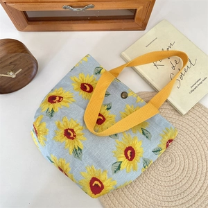 Detail of light blue sunflower canvas tote with yellow handles and magnetic closure