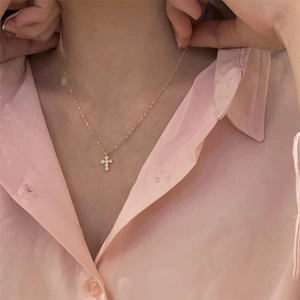 Close-up of a delicate 925 sterling silver cross necklace with pavé-set zirconias