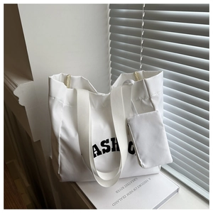 Detailed view of the large white Oxford tote bag and matching small pouch on a windowsill