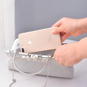Sparkling silver rhinestone evening clutch bag with chain strap showing phone capacity