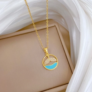 Close-up of golden fishtail necklace with blue enamel and pavé crystals on silk