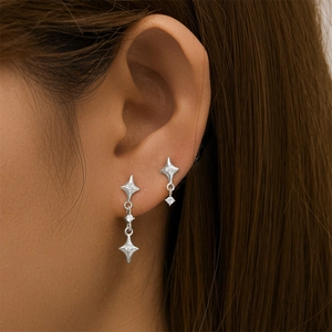 Close-up of S925 sterling silver star drop earrings with sparkling clear gemstones on ear