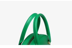 Detailed top view of a green jelly bag featuring a smooth handle and golden metal accents