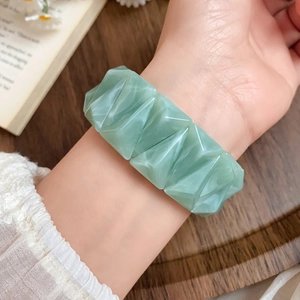 Detail of light green marble texture acrylic geometric thick bracelet on wrist