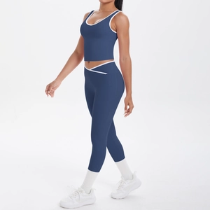 Dark blue two-piece yoga set featuring a contrast trim sports bra and V-cross waist leggings