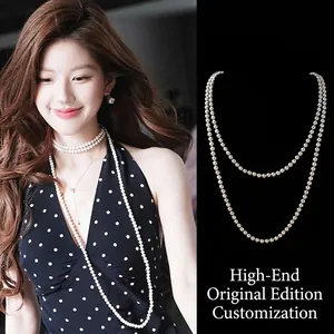 Close-up of elegant double-layered pearl necklace set on model and dark background