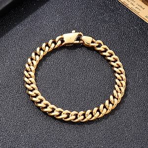 Detailed top-down shot of a gold-plated Cuban link bracelet on a black textured surface