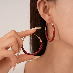 Vintage dark red and gold hoop earrings shown on a model in a profile close-up view