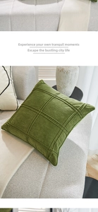Detail of dark green velvet pillow cover with 3D waffle texture on a modern sofa