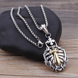 Detailed close-up of a silver shield pendant with a gold sword and cross on black stone