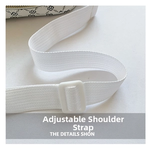 Detail of adjustable white nylon shoulder strap with plastic buckle on printed handbag