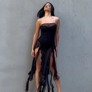 Detail of black mesh tube dress featuring sheer panels and irregular fringe hemline