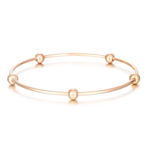 Minimalist rose gold stainless steel bangle featuring five polished metallic beads