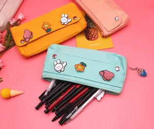 Detailed view of canvas pencil cases with metal buckles and cute cartoon animal pins