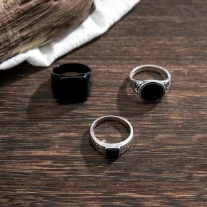 Men's retro mixed alloy rings set with black stones on dark wood background