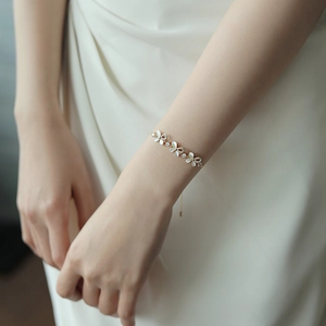 Elegant gold flower bracelet featuring shell texture petals and sparkling zircon stones