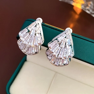Détail de boucles d'oreilles argentées en éventail avec zircons sur un écrin de bijoux
