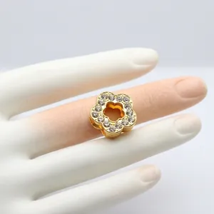 Macro view of gold flower charm with clear rhinestones for DIY bracelet accessories