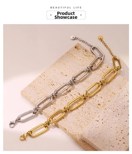 Detail of gold and silver chunky chain link bracelets with lobster clasp on stone surface