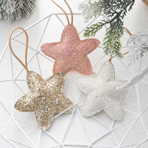 Pink, gold and white glittery star Christmas tree ornaments in a white metal basket