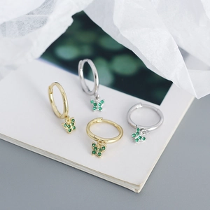 Close-up of S925 silver butterfly hoop earrings with green zircon in gold and silver