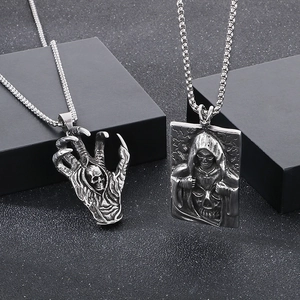 Detailed view of silver gothic claw and grim reaper pendants on black display blocks